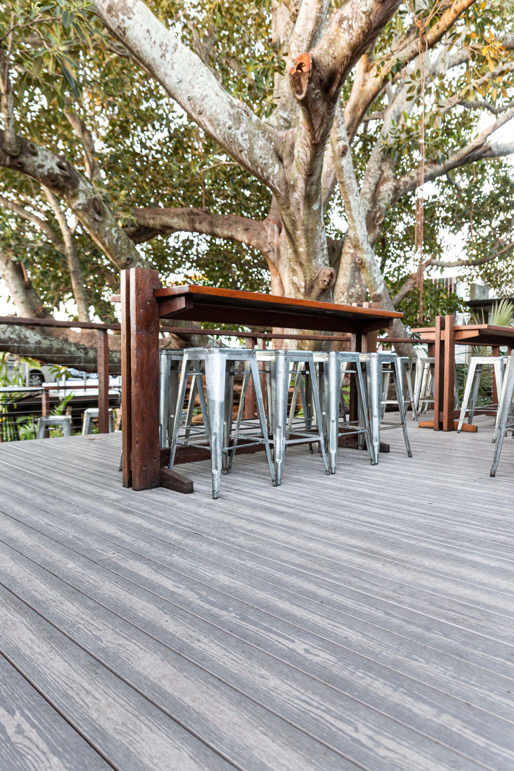 Bar stools and a table installed on a grey silver composite deck patio