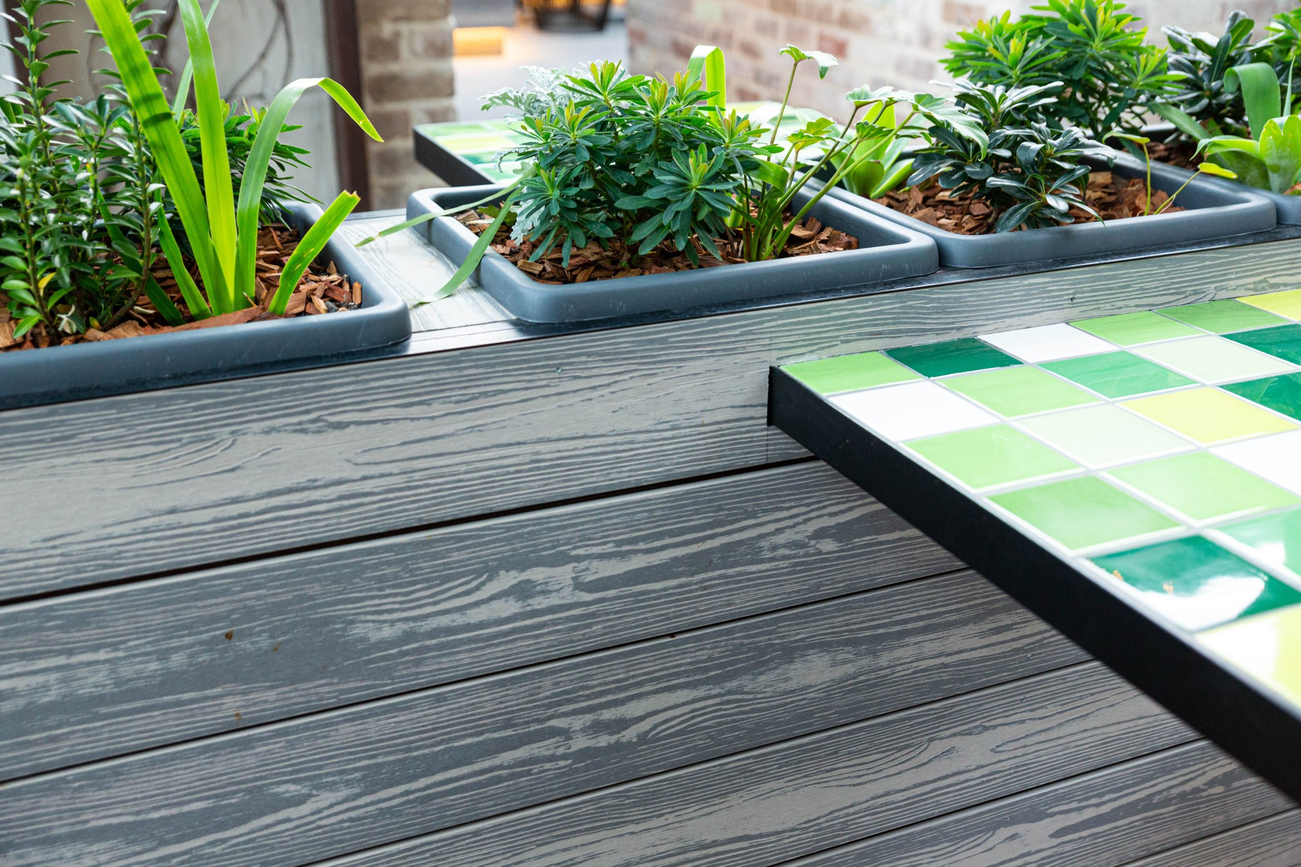 A close up of silvery grey composite boards used to construct planter boxes