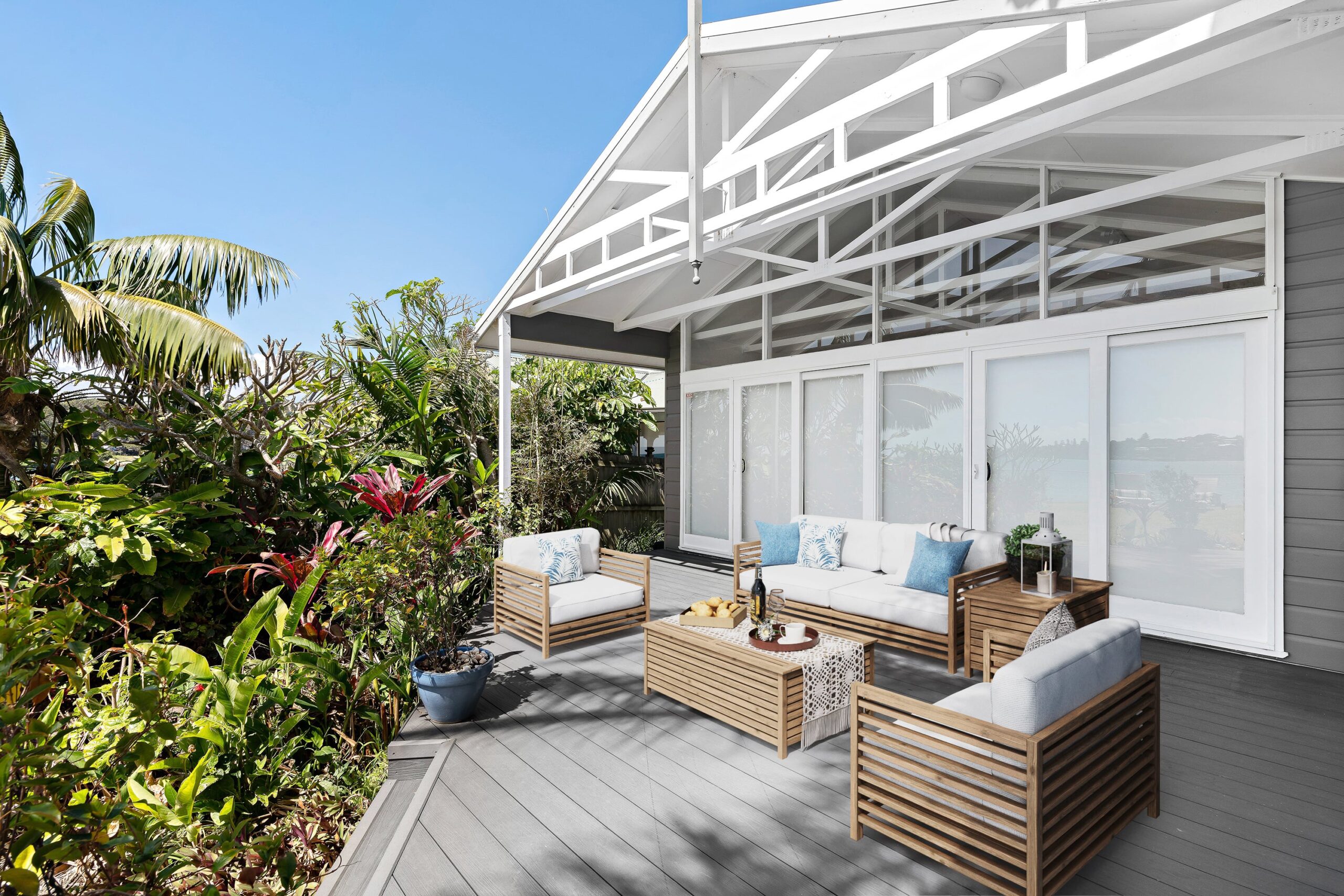 A composite deck built at the corner edge of a home, patio furniture on top