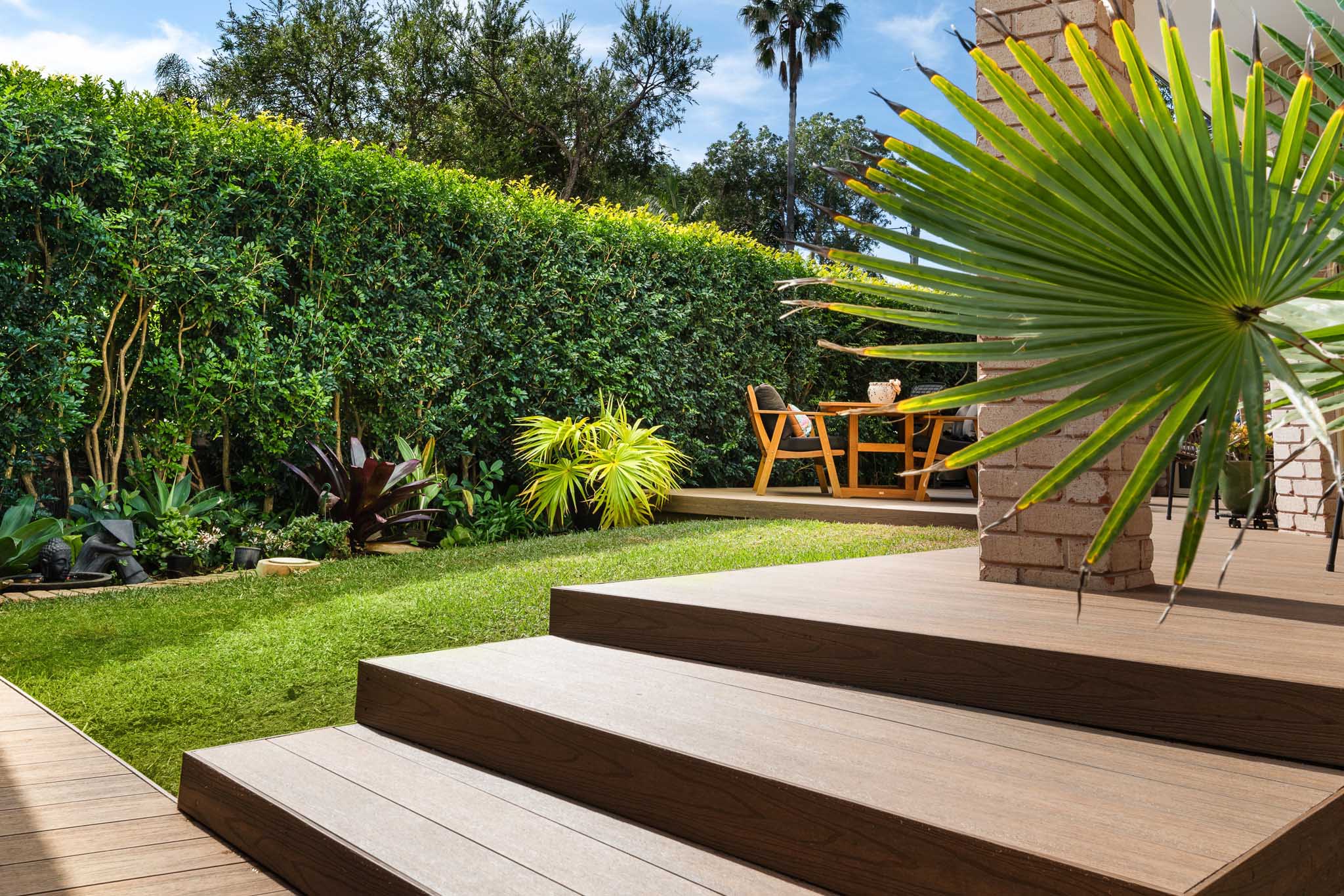 3 wide-length Teak composite decking boards with a plant at the top