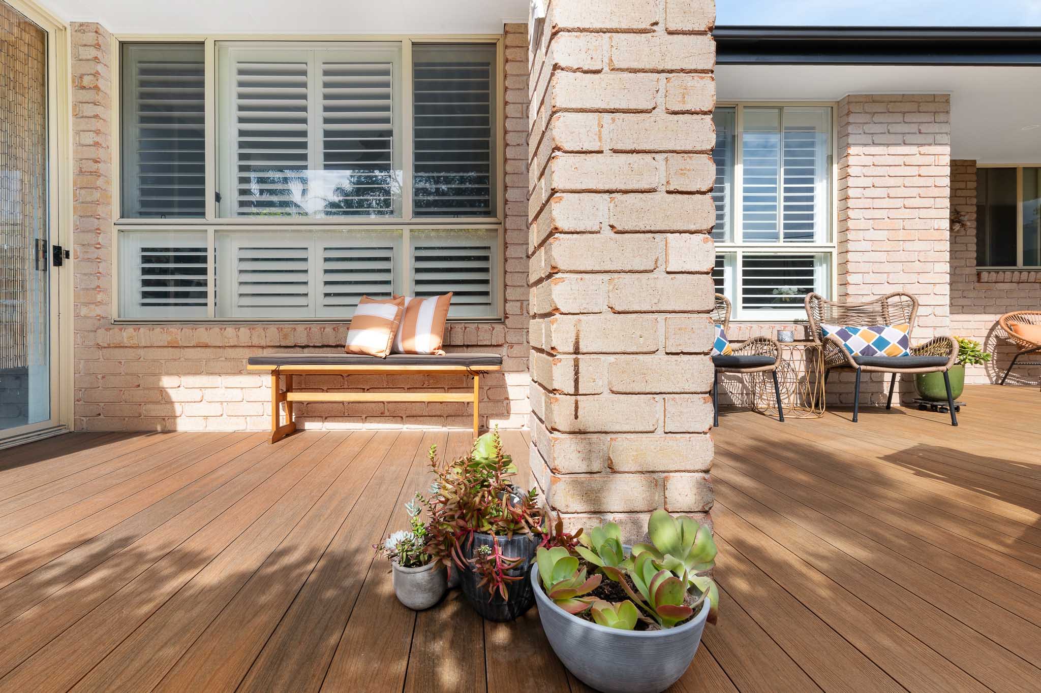 Teak composite decking boards with a brick pillar in the middle