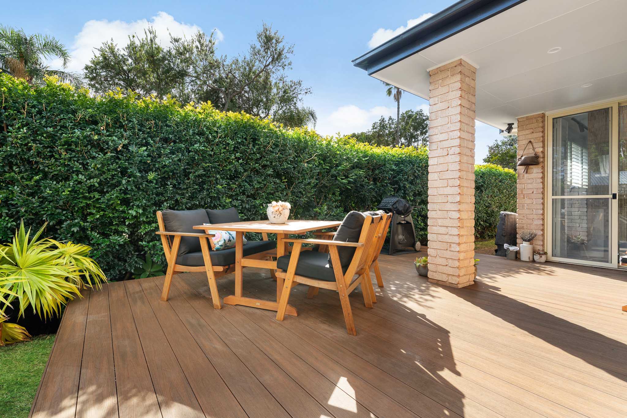 Teak composite decking boards with a small table and chairs on top of them