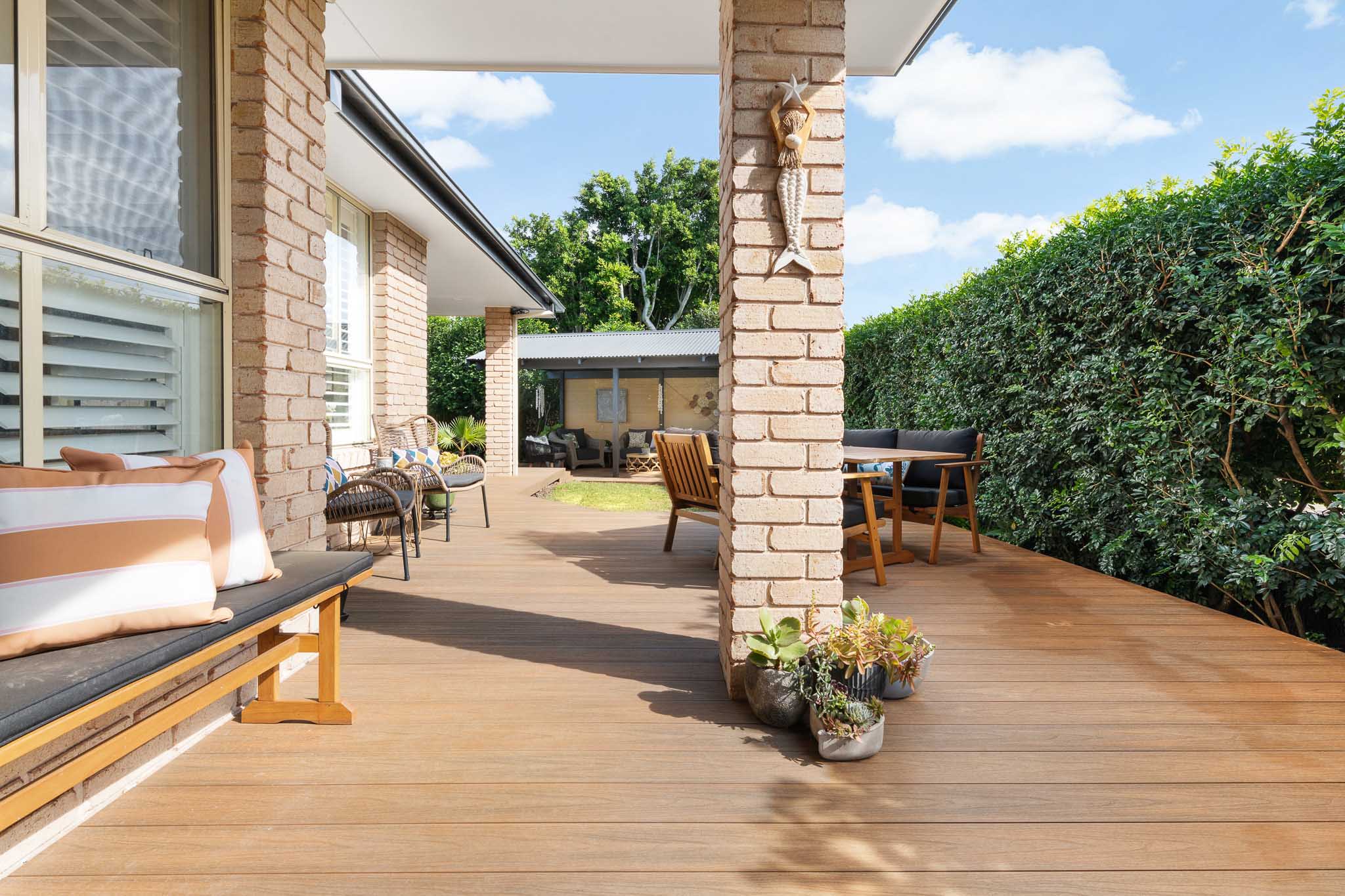 A patio alongside of a brick home, built with Brite composite decking boards