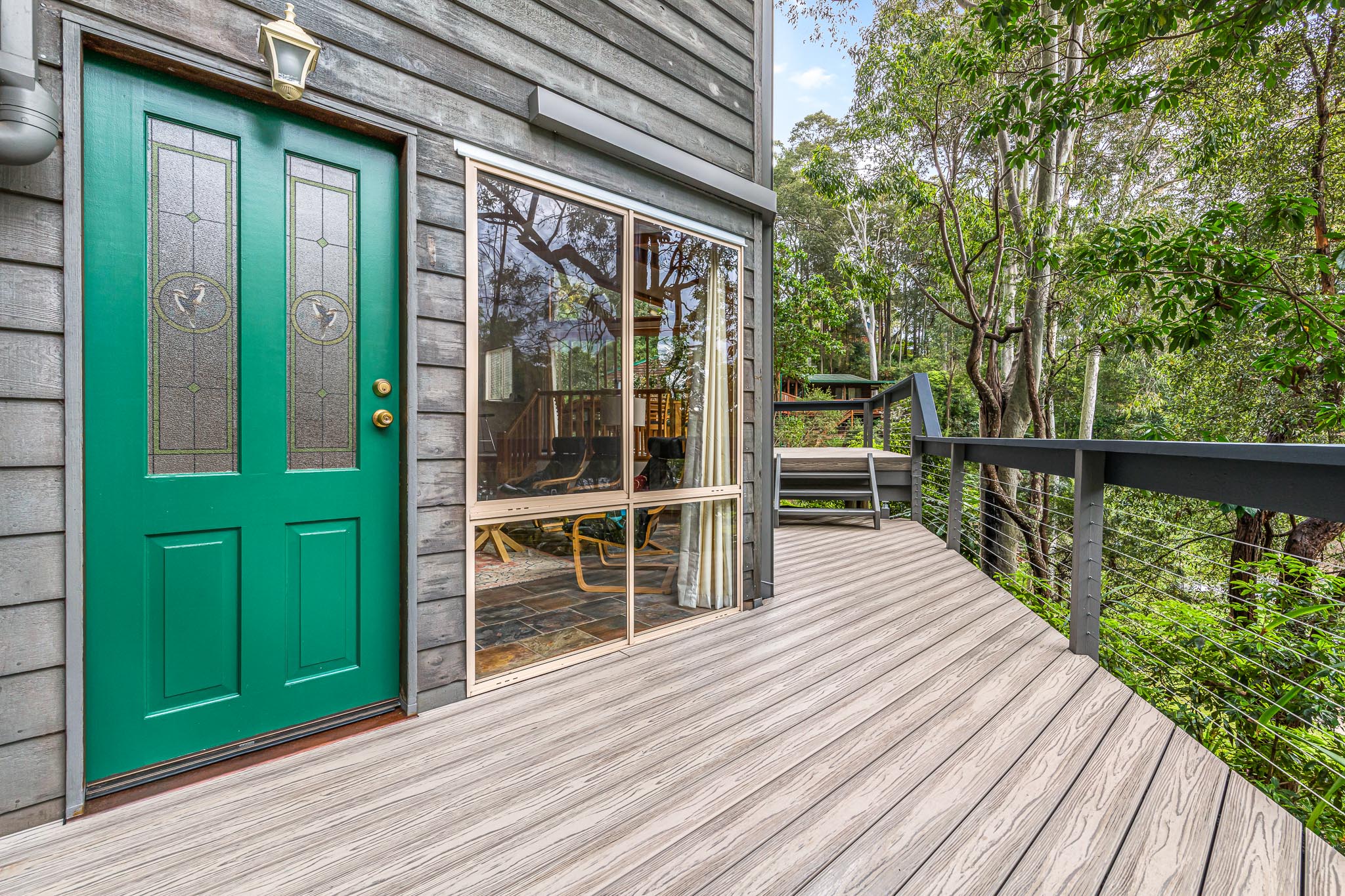 Silver Gray Next Gen Titanium Decking Boards leading to a bright green front door