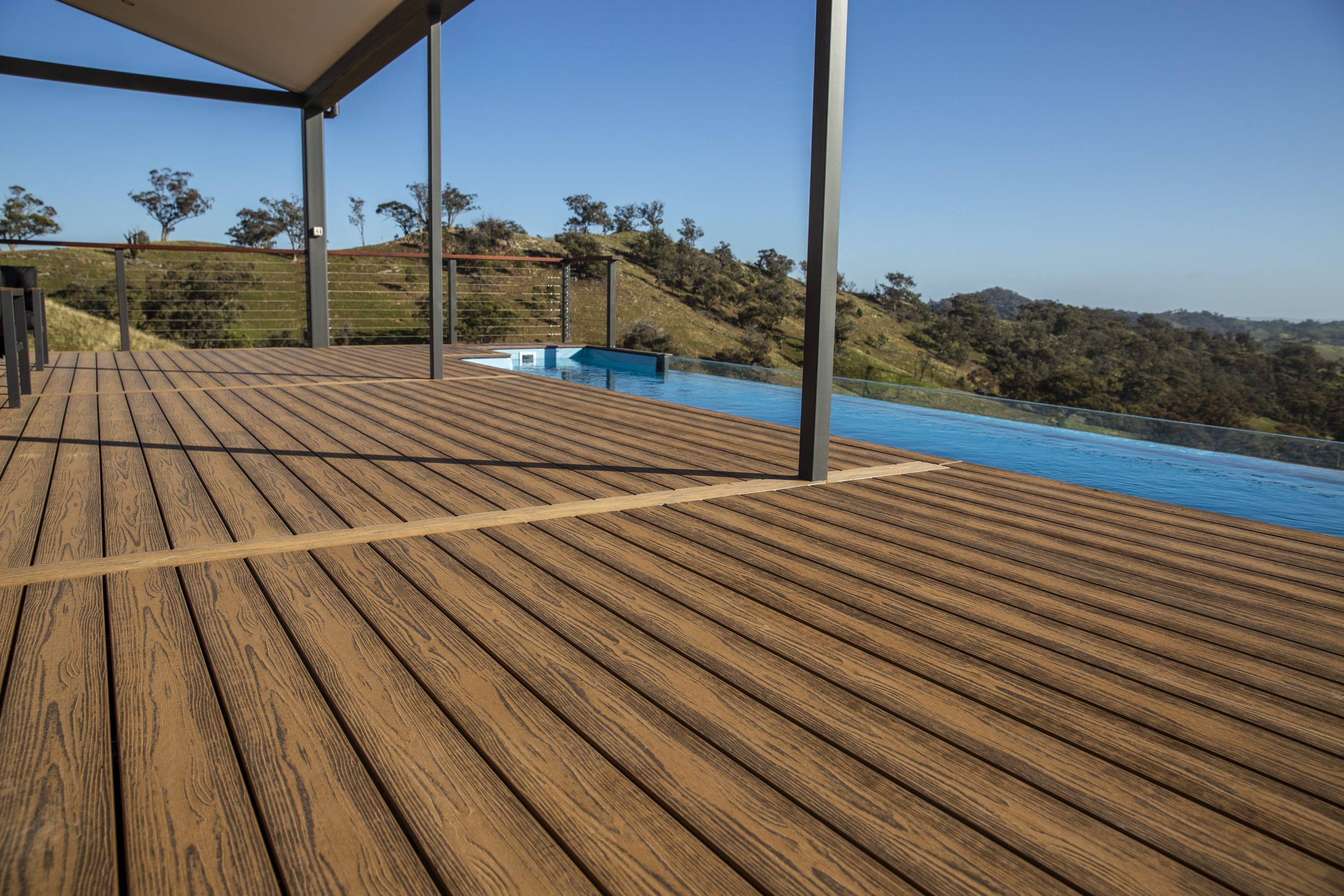 Brite composite decking boards next to a large, in ground swimming pool