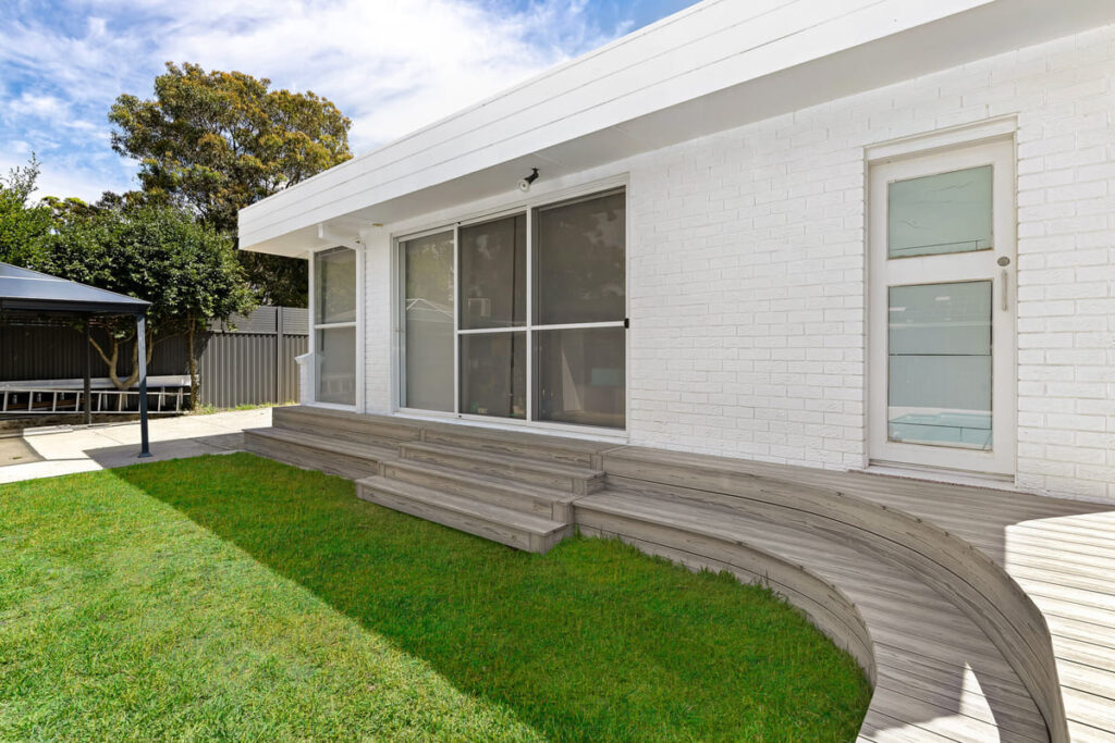 a house with a lawn and a grey composite decking steps