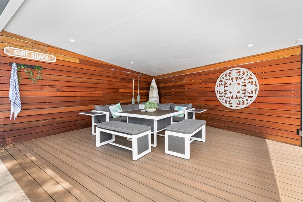 a patio installed with a composite decking boards with a table and benches