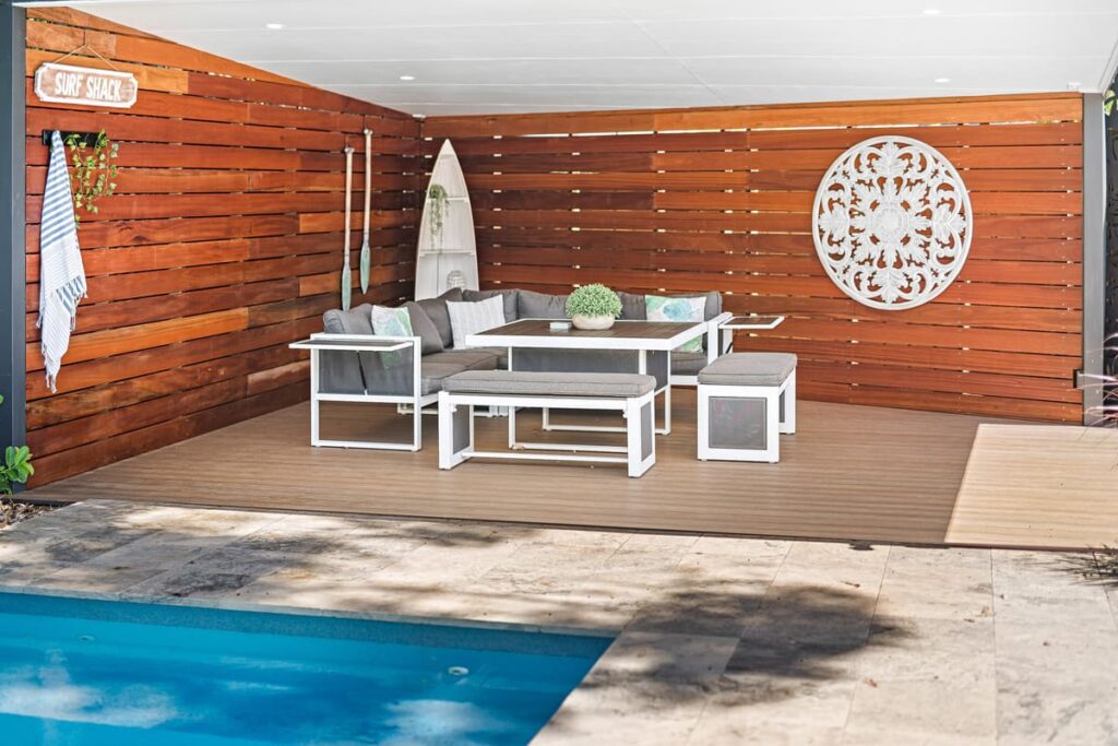 a patio installed with Composite DEcking boards with a pool and a table