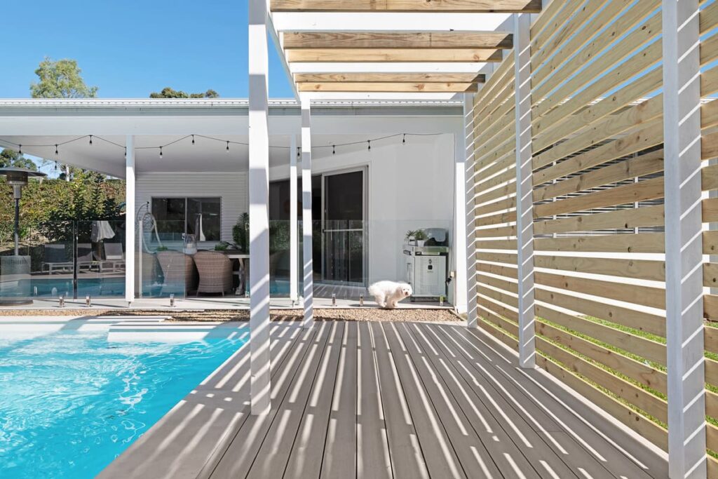 a composite deck with a pool in the background