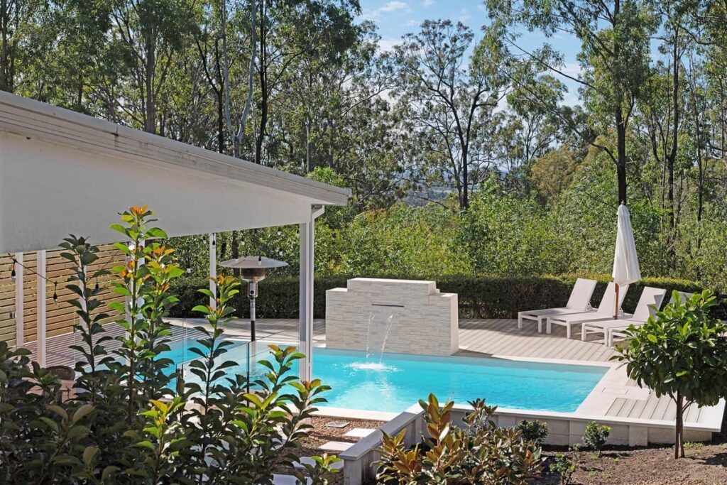 a pool deck using a composite decking with a fountain in the back