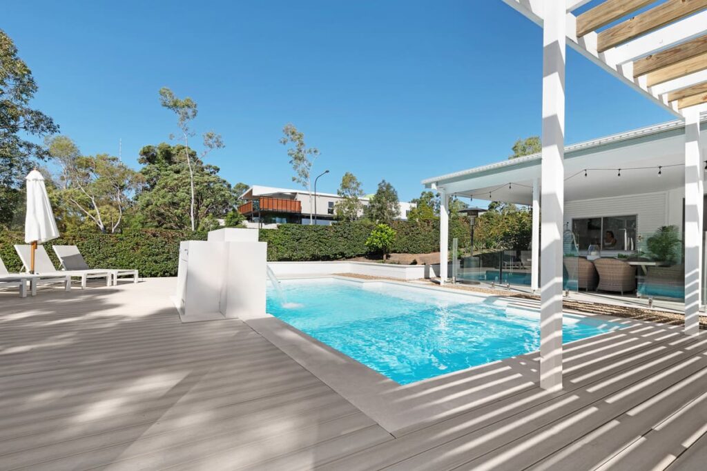 a pool deck with a waterfall in the middle of a house