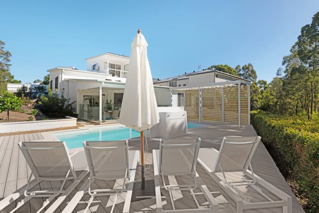 a pool with a decking chair and umbrella