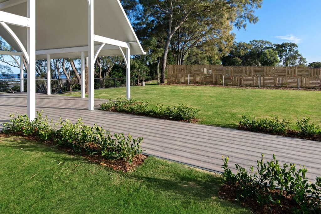 a grey composite decking walkway leading to a gazeebo