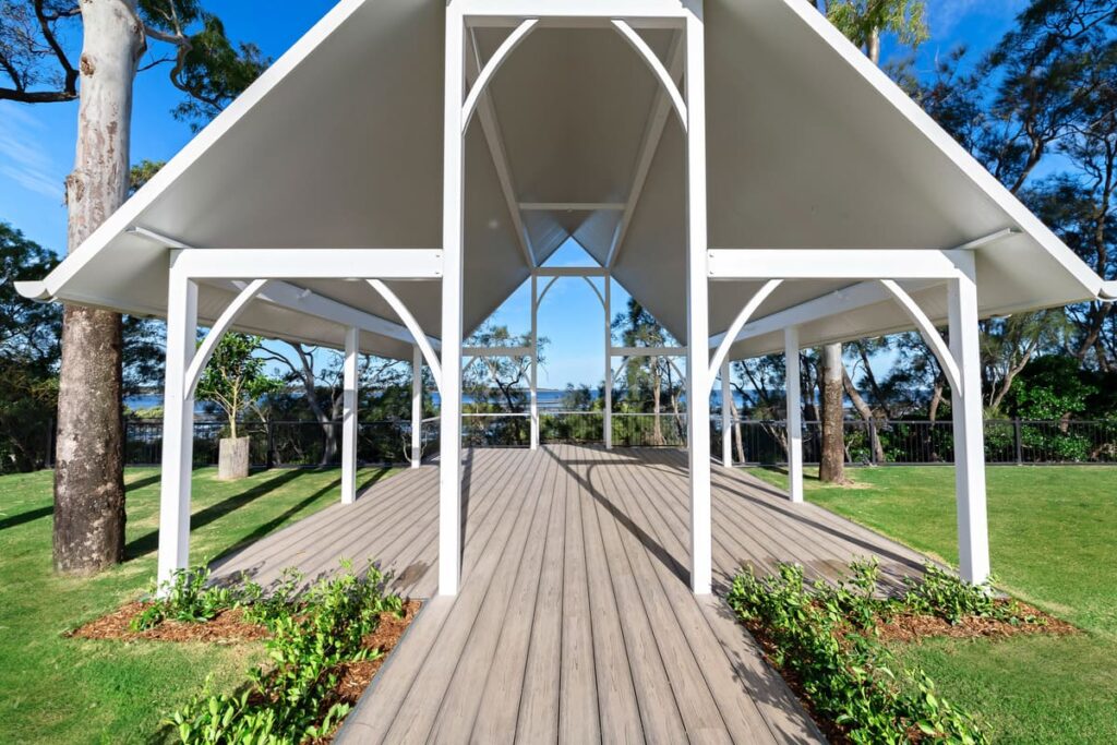 sandstone point project 13 a white gazebo with a grey composite deck and grass and trees