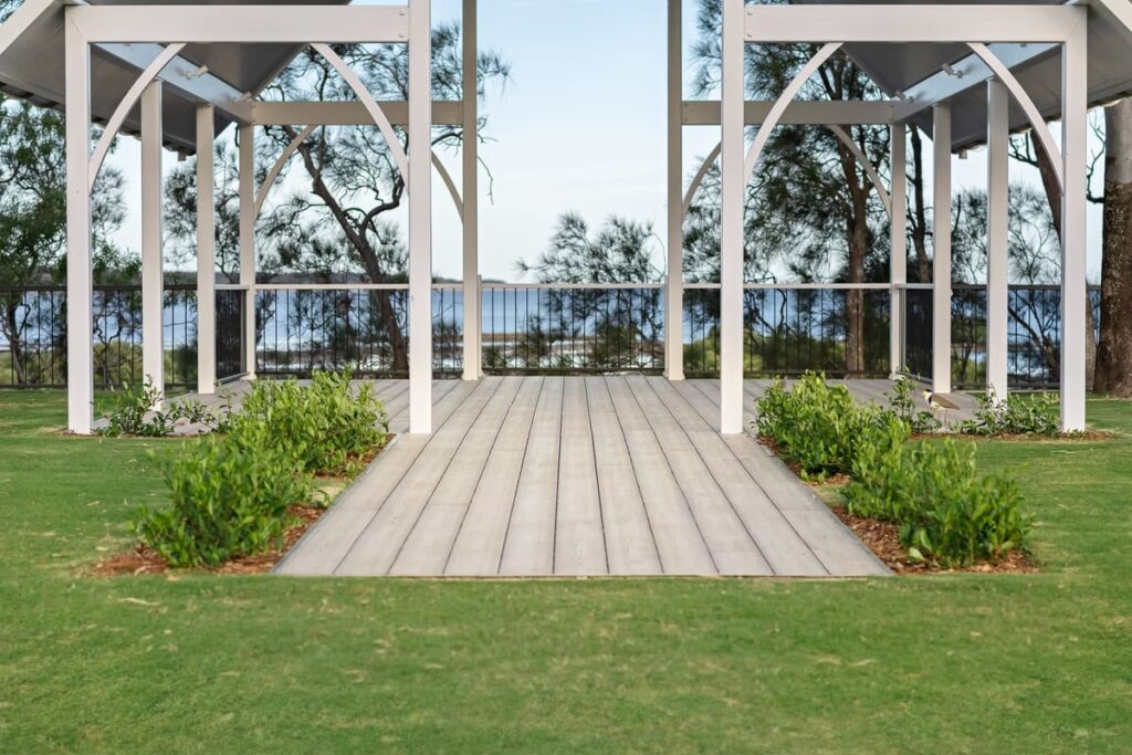 a grey composite deck with a wood walkway and plants