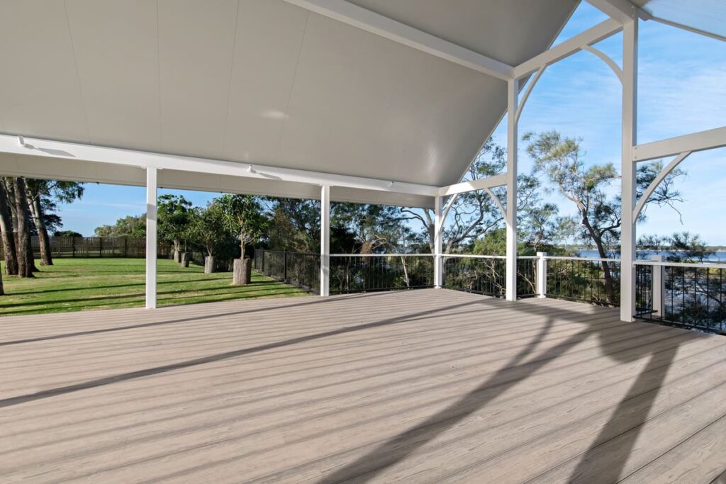 a composite deck with a white roof and a fence and trees