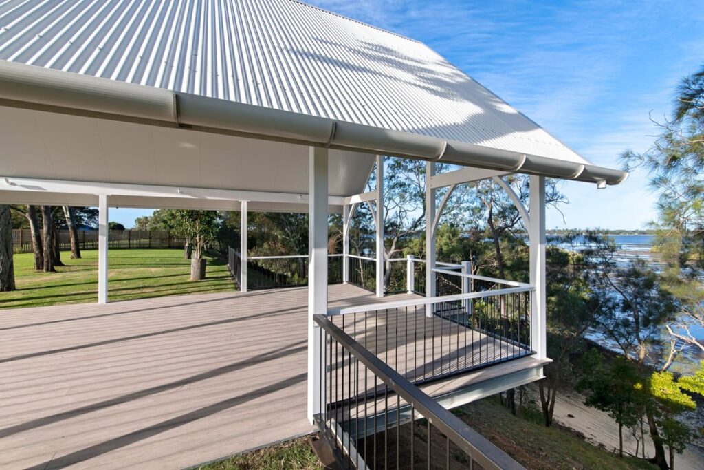 a composite deck with a white roof and a metal railing