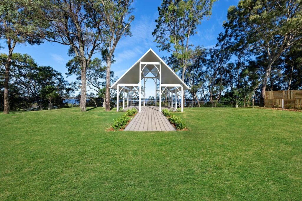 a white structure with composite decking installed on a grassy field
