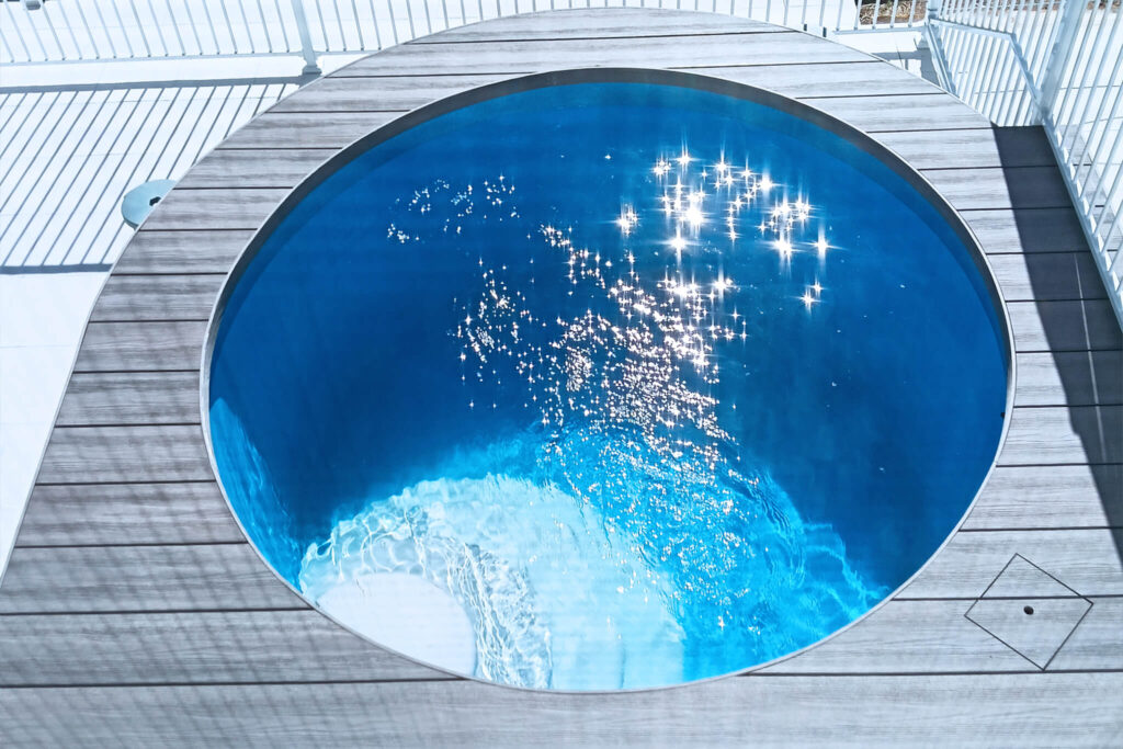Above view of a round pool surrounded by composite decking in NextGen Titanium Fossil colour, installed in Buderim QLD