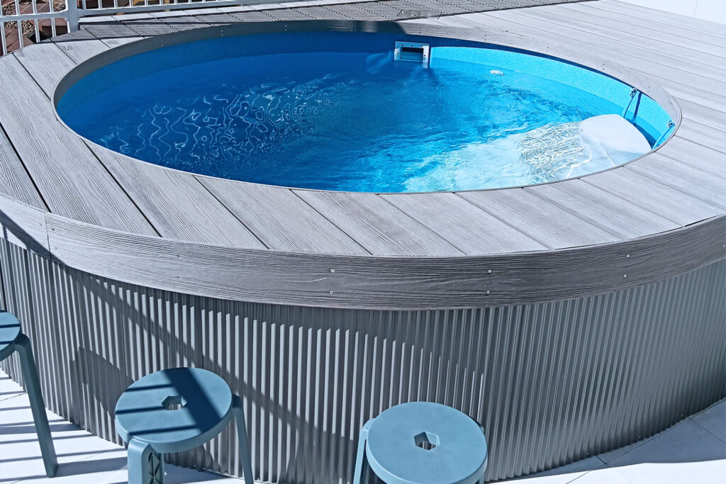 Side view of a circular pool with grey composite decking in NextGen Titanium Fossil colour, Buderim QLD installation.