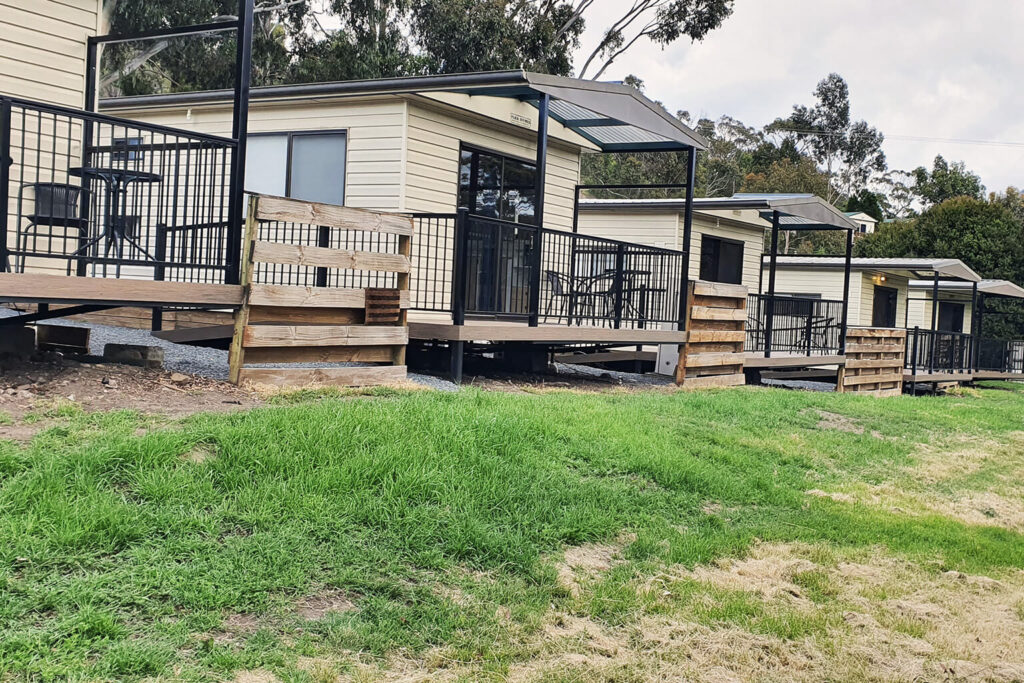 Row of cabins upgraded with composite decking Tasmania at Discovery Parks Hobart holiday park.