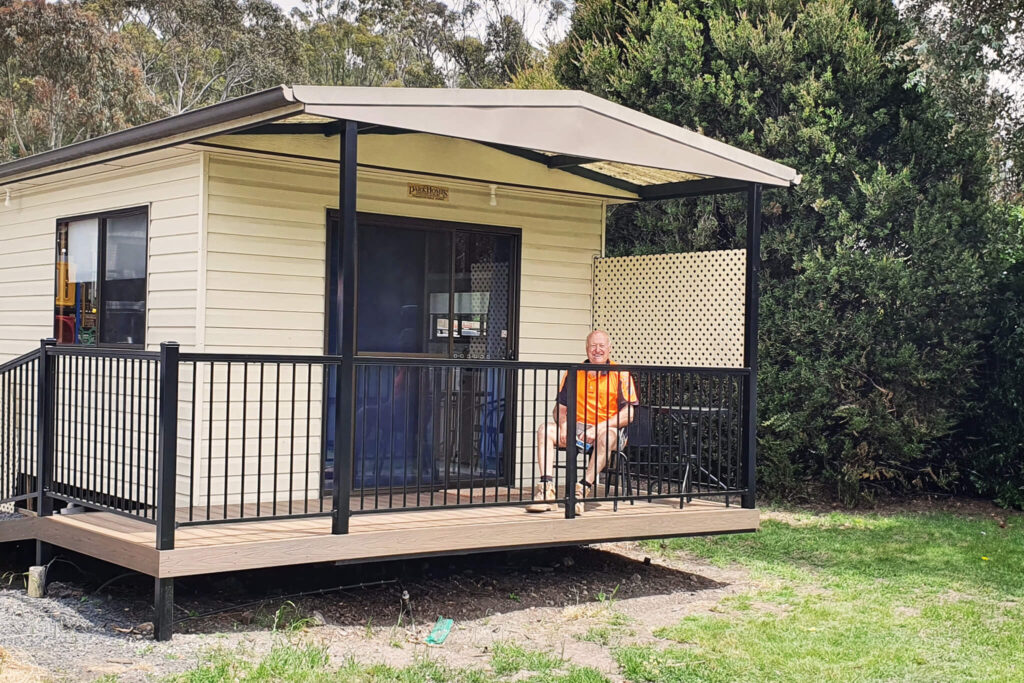 Cabin porch featuring composite decking Tasmania with black railing at Discovery Parks Hobart.